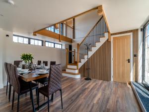 a dining room with a table and chairs and a staircase at Stable View Barn - Uk45938 in Corley