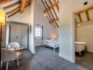 a bedroom with a tub and a bed and a sink at Stable View Barn - Uk45938 in Corley