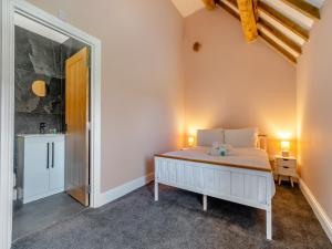 a bedroom with a large bed and a bathroom at Stable View Barn - Uk45938 in Corley