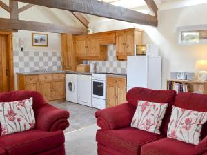 een keuken met twee rode stoelen en een witte koelkast bij Shyre Stable - 18437 in Bempton