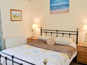 een slaapkamer met een bed met twee nachtkastjes en twee lampen bij Shyre Stable - 18437 in Bempton