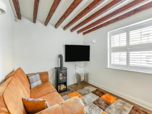 a living room with a couch and a flat screen tv at Rose Cottage - Uk45971 in Yarm