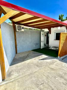 a patio with a red awning on a house at Studio cosy équipé à 5min de la plage in Vieux-Habitants