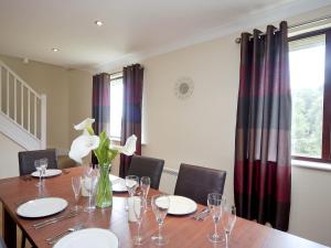 a dining room table with glasses and flowers in a vase at Lake View Cottage - Cv7102 in Saint Cleer