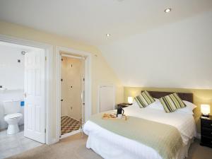 a bedroom with a bed and a bathroom with a toilet at Lake View Cottage - Cv7102 in Saint Cleer