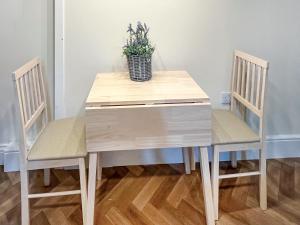 un tavolo e sedie in legno con una pianta in vaso in cima di Marsay Cottage a Loftus