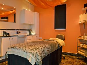 a kitchen with orange walls and a bed in a room at The Bakery - Uk6727 in Lydstep