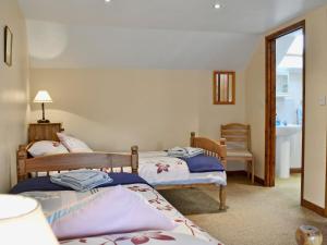 Habitación con 3 camas y baño con lavabo. en Bolland Barn, en Northlew