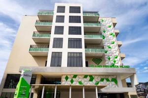 a building with a green and white facade at Grand Permata Hijau Hotel in Sukabumi