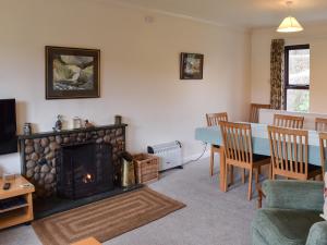 a living room with a fireplace and a table at Ghyllside 3 in Ambleside