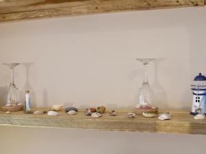 a shelf with four glass bottles and stuffed animals at Divers Cottage in Herne Bay +10 photos