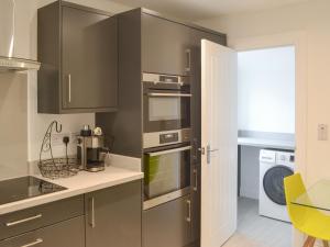 a kitchen with gray cabinets and a washer and dryer at Ad Gefrin in Acklington +16 photos