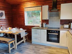 RashfieldにあるWillow Lodgeのテーブルとコンロのあるキッチン トップオーブン