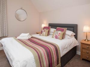 ein Schlafzimmer mit einem Bett mit weißen Laken und Kissen in der Unterkunft Puffin Cottage - Uk6731 in Lydstep