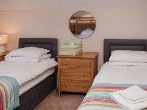 1 Schlafzimmer mit 2 Einzelbetten und einem Spiegel in der Unterkunft Puffin Cottage - Uk6731 in Lydstep