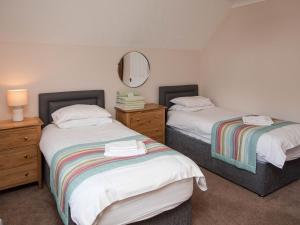 1 Schlafzimmer mit 2 Betten, einem Spiegel und einer Kommode in der Unterkunft Puffin Cottage - Uk6731 in Lydstep + 8 Fotos