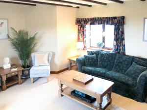 a living room with a green couch and a table at Chapman House in Parkham