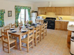 a kitchen with a wooden dining table and chairs at Chapman House in Parkham