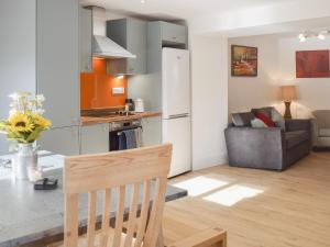 a kitchen and living room with a table and a couch at Delfryn in Llanarth