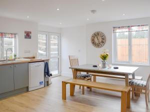 a kitchen and dining room with a table and chairs at Delfryn in Llanarth