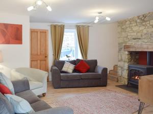 a living room with a couch and a fireplace at Delfryn in Llanarth