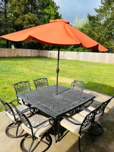 an orange umbrella sitting on a table with chairs at Rest and retreat river house in Grants Pass
