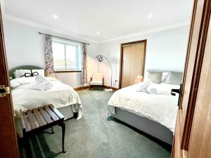 ein Schlafzimmer mit zwei Betten und einem Fenster in der Unterkunft Golf View Spacious Bungalow 2 Bathrooms, Free Parking WiFi in Elgin