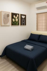 a bedroom with a blue bed with a remote control on it at Bae Homestay Taman Mega Alor Setar Wi-Fi Netflix 