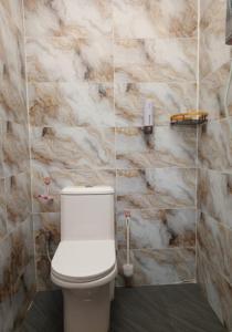 a bathroom with a white toilet and a marble wall at Bae Homestay Taman Mega Alor Setar Wi-Fi Netflix 