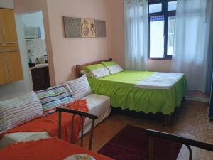 a room with a bed and a couch in it at Kitnet in Praia Grande