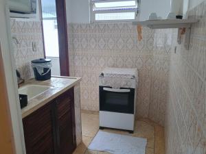 a small kitchen with a sink and a stove at Kitnet in Praia Grande