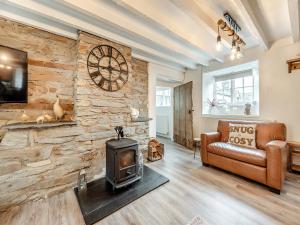 ein Wohnzimmer mit einer Steinmauer und einem Herd in der Unterkunft Old Stables Cottage in Blaenporth