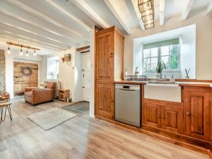 eine Küche mit Holzschränken und ein Wohnzimmer in der Unterkunft Old Stables Cottage in Blaenporth + 26 Fotos