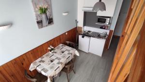 a dining room with a table and a kitchen at Hôtel de la Place in Germigny-des-Prés