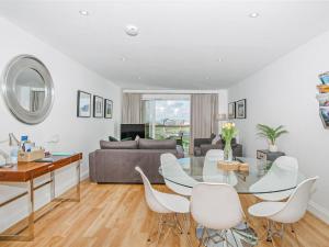a living room with a glass table and white chairs at 50 Bredon Court in Newquay