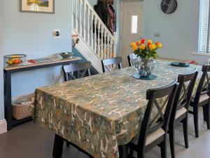 a dining room table with a vase of flowers on it at Brookfields in Slingsby +25 photos