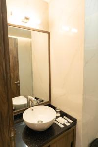 a bathroom with a white sink and a mirror at Grand Permata Hijau Hotel in Sukabumi