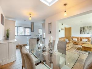a dining room and living room with a glass table and chairs at The Hideaway in Chapel Saint Leonards