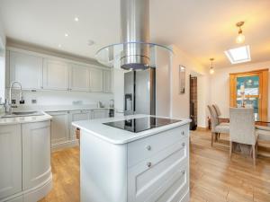 a kitchen with white cabinets and a kitchen island at The Hideaway in Chapel Saint Leonards +11 photos