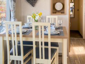 een eettafel met 2 witte stoelen en een tafel met glazen bij Deer View in Felton