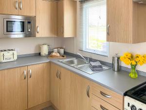 een keuken met een spoelbak en een magnetron bij Deer View in Felton