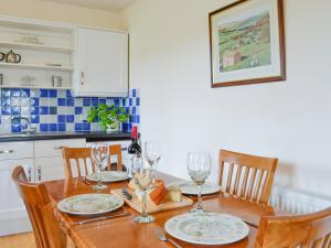 a kitchen with a wooden table with chairs and wine glasses at Peace in Whauphill