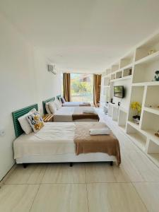 1 Schlafzimmer mit 3 Betten und einem Fenster in der Unterkunft Pousada MarÍsis Barra da Tijuca in Rio de Janeiro