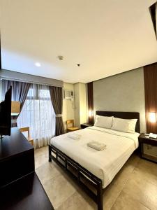 a bedroom with a large bed and a window at kasa Boutique Hotel Capitol in Cebu City