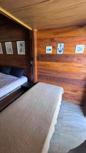 een kamer met twee bedden en foto's aan de muur bij Chalé de Madeira, a 60m do mar em condomínio in Vera Cruz de Itaparica