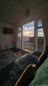 a bedroom with a large window with a view of the desert at Welsh Bayview Retreat 2-Bed Lodge at Clarach Bay Holiday Village in Aberystwyth +42 photos
