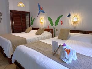 two beds in a hotel room with two bags on them at Hotel Villas Rio Mar in Dominical