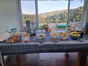 a table with many bowls of food on it at Pousada Essenza lindoía in Águas de Lindoia