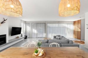 a living room with a couch and a table at Riverhaus Luxe Barwon Heads Retreat with Pool in Barwon Heads