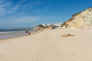 a group of people walking on the beach at NAU Salema Beach Village in Salema